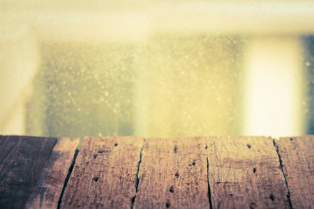 Old wood table and glass window with drop water