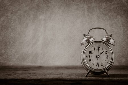 Vintage background with retro alarm clock on table,noise with grain.black and whiteの写真素材