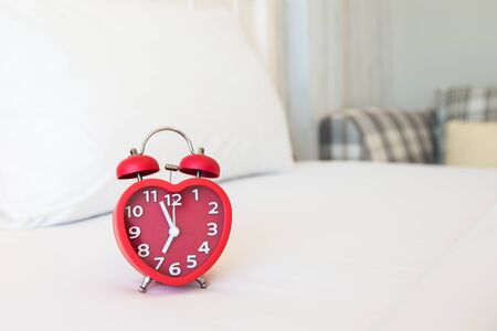 Red heart alarm clock in bedroom
