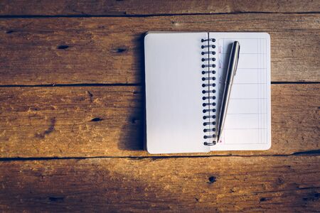 blank notebook with pen on a old wooden table