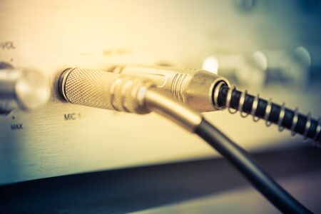 Microphone connectors plugged in a audio music mixing console. Vintage style photo and filtered...