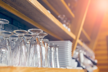 Empty glasses for drink above a bar rack in vintage tone.の写真素材