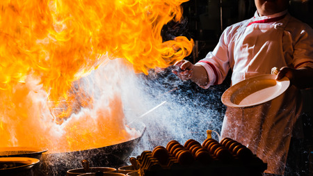 Fire burn is cooking on iron pan,stir fire very hotの写真素材