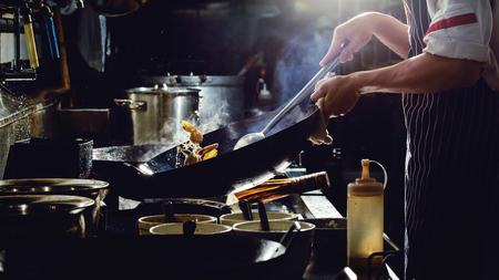 Chef is stirring vegetables  in wokの写真素材