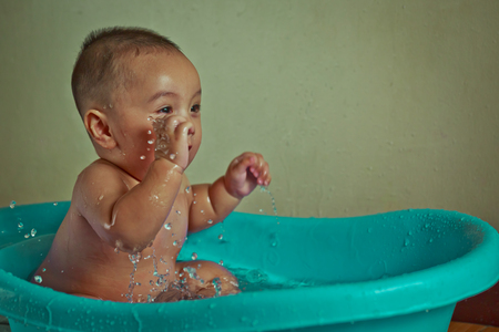 Baby 7 months playing water funny. vintage filter