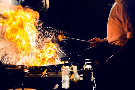 Chef is stirring vegetables in wokの写真素材