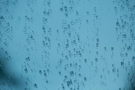 Water drops of rain on a window glass rain backgroundの写真素材