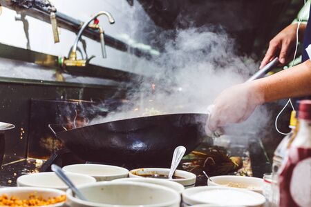 Chef stir fry vegetable in kitchenの写真素材