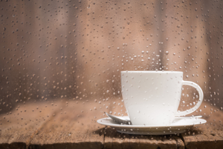 Coffee cup on a rainy day window backgroundの写真素材