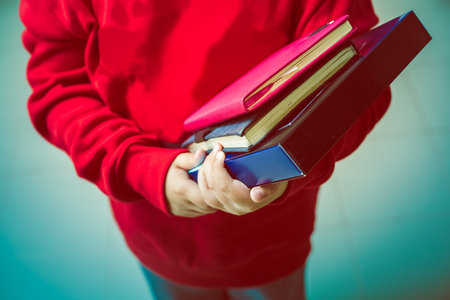 Student wearing red shirt holding the books for education conceptの写真素材