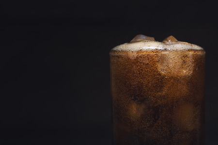 close up cola in glass, glass of cola with ice with copy-space on dark backgroundの写真素材