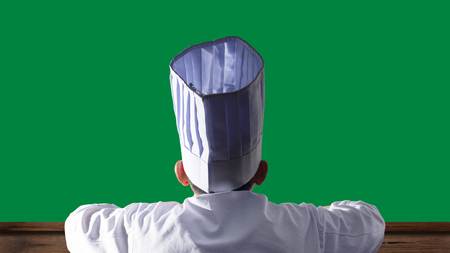 Back of chef on green isolated backgroundの写真素材