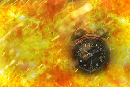 Alarm clock is on big fire flames are coming from it: time is burningの写真素材