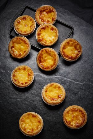Egg tart, traditional Portuguese dessert, pastel de nata on black tileの写真素材