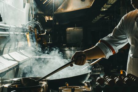 Chef stir fry in wok. Dramatic cooking with fire hardの写真素材