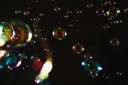 Blur Abstract colorful soap bubbles wallpaper isolated on black backgroundの写真素材