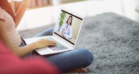 Patient talk consult with doctor using video call on laptop, woman speak discuss health problem with physician on video call  from home, Online consultation conceptの写真素材