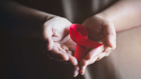 World AIDS day awareness ribbon,Female hands holding red ribbon HIV,Healthcare and medicine concept.の写真素材