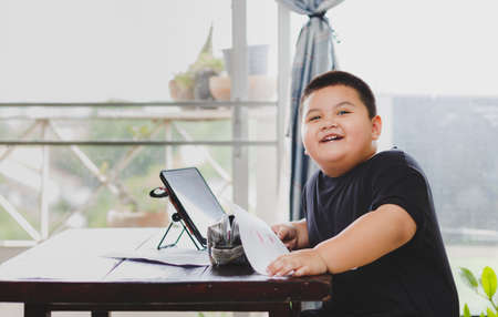 Cute Asian kid learning class study online  from tablet at home .Social distancing conceptの写真素材