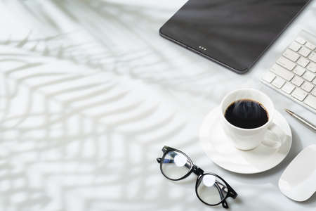 Hot coffee with an office desk and modern palm shadows.の写真素材