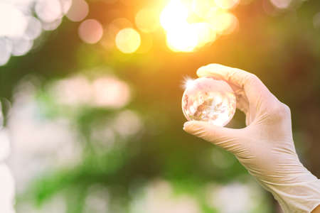 Globe glass on hand with sunrise at river bankの写真素材