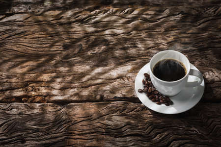Coffee cup with light and shadow on old woodの写真素材
