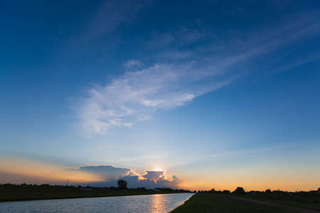 Clouds with reflection on river at sunset or sunriseの写真素材