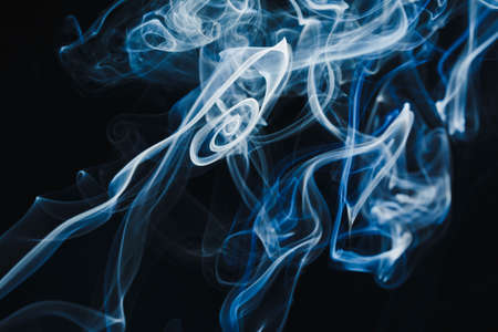 Smoke floating in the air on dark backgroundの写真素材
