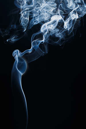 Smoke floating in the air on dark backgroundの写真素材