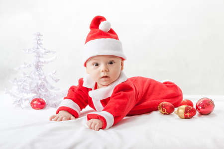 baby Santa Claus with a Christmas tree and toysの写真素材