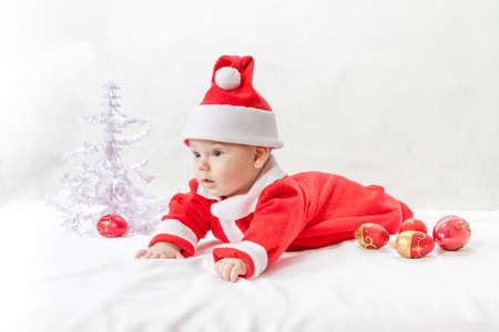 baby Santa Claus with a Christmas tree and toysの写真素材