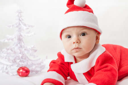 baby Santa Claus with a Christmas tree and toysの写真素材