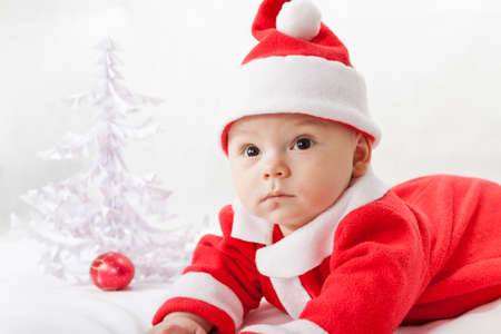 baby Santa Claus with a Christmas tree and toysの写真素材
