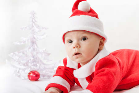baby Santa Claus with a Christmas tree and toysの写真素材