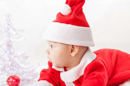 baby Santa Claus with a Christmas tree and toysの写真素材