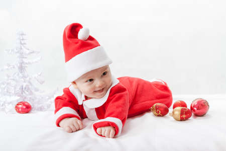 baby Santa Claus with a Christmas tree and toysの写真素材