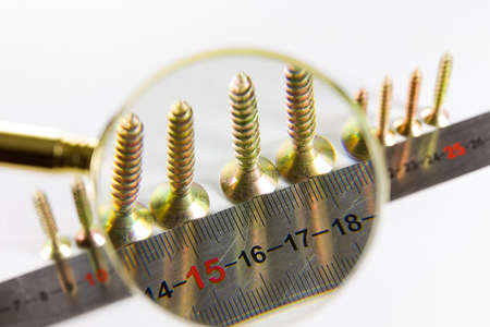 wood screws through a magnifying glassの写真素材