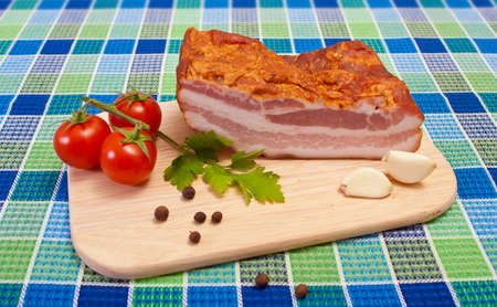 Bacon with Cherry Tomatoes, Parsley, Pepper and Garlic on a Cutting Boardの写真素材