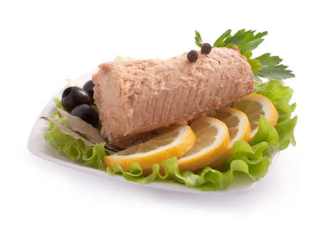 Composition with Canned Pink Salmon Steak Isolated on White Background with Lemon, Olives, Pepper, Parsley, Laurel and Salad Leavesの写真素材