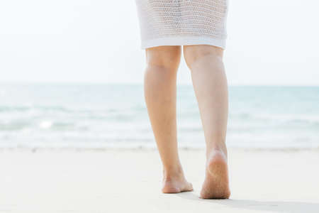 Asian woman walking into the sea : Focus at the soleの写真素材