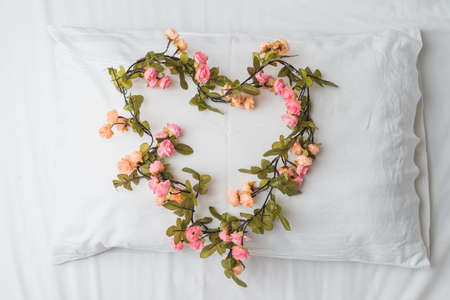 Heart shape bouquet on white pillowの写真素材