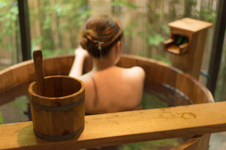 Onsen series : Unrecognizable woman in wooden bathtub