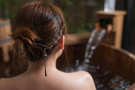 Onsen series : Unrecognizable woman in wooden bathtub