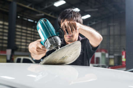 Car polishing series : Worker waxing white car