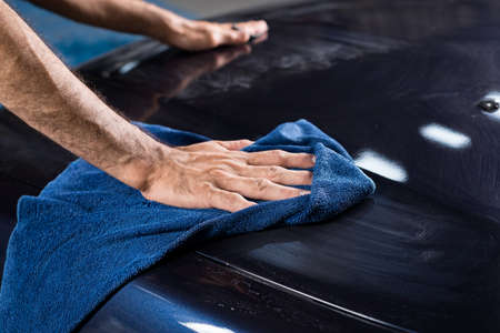 Car polishing series : Worker wiping blue car