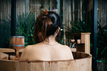 Onsen series : Unrecognizable woman in wooden bathtubの写真素材