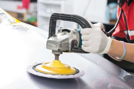 Car polishing series : Worker waxing grey car