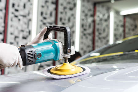 Car polishing series : Worker waxing grey car