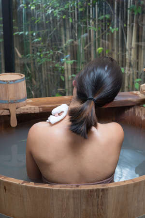 Onsen series : Unrecognizable woman in wooden bathtubの写真素材