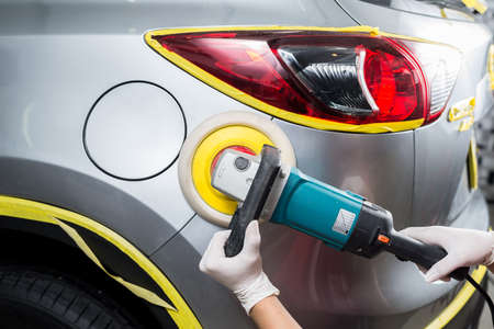 Car polishing series : Worker waxing grey car